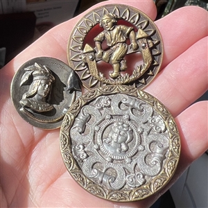 Three brass people buttons including a Kate Greenaway.