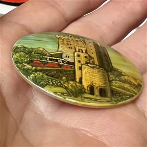 Castle painted on shell studio button signed “Shaw.”