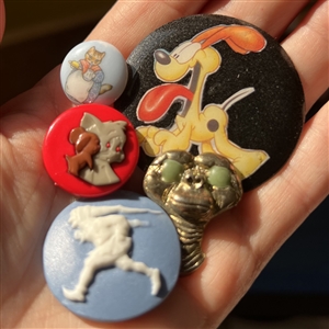 Five assorted buttons of cartoon characters etc.