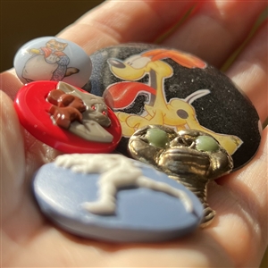 Five assorted buttons of cartoon characters etc.