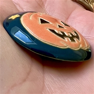 Ceramic Halloween pumpkin button by Golem Design Studio.
