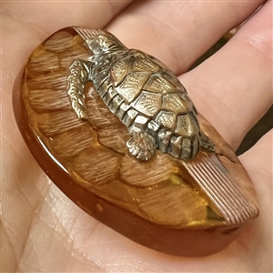 Brass sea turtle over apple juice Bakelite button.