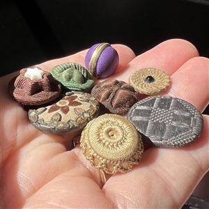 Eight assorted fabric buttons.