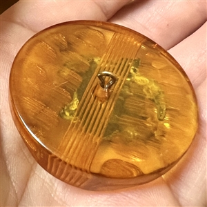 Brass sea turtle over apple juice Bakelite button.