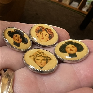 Set of four paper under celluloid sheet (?) set in metal buttons.
