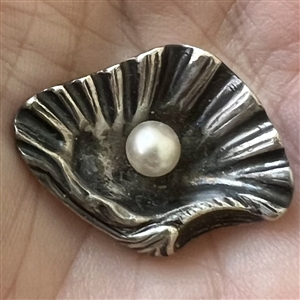 White metal button of realistic shell with pearl.