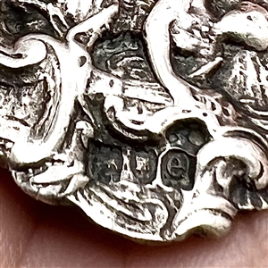 Hallmarked silver button of a woman playing a lyre. 