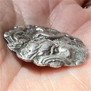 Hallmarked silver button of a woman playing a lyre. 