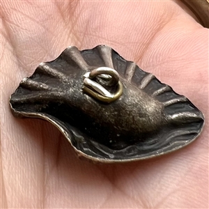 White metal button of realistic shell with pearl.