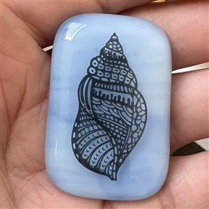 Fused glass studio button with transfer of a shell by Mona Ledwin.