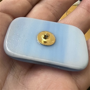 Fused glass studio button with transfer of a shell by Mona Ledwin.