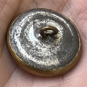 Brass button of a monkey in a tree.