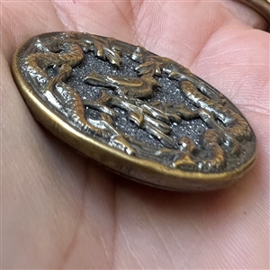 Brass button with galena of a bird surrounded by two snakes.