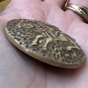 Vintage celluloid button of polo player on a horse.