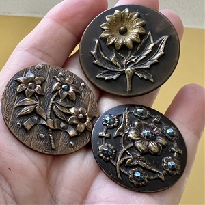 Three Victorian brass buttons of flowers.