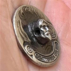 Art Nouveau style Battersea pewter button of a woman with flowing hair.