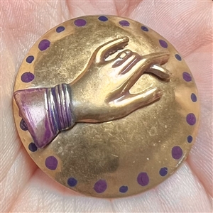 Brass studio button of a hand.