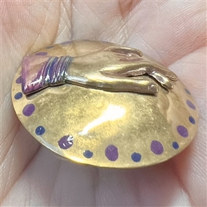 Brass studio button of a hand.