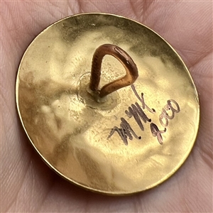 Brass studio button of a hand.
