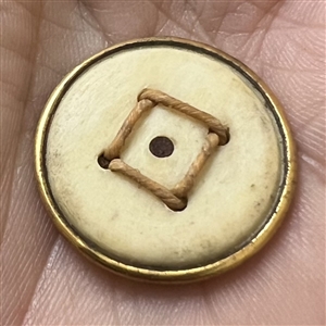 An 18th c. woven gold metal cap button of death's head design.