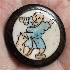 Natural material in boxwood button of an Asian boy playing with a cat.