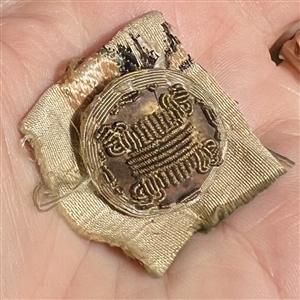 An 18th c. Passementerie button with gold bullion on original fabric.