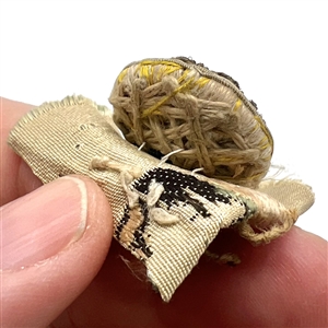 An 18th c. Passementerie button with gold bullion on original fabric.