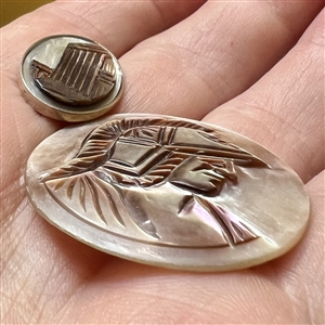 Two cameo carved pearl buttons.