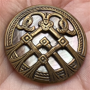 Iridescent pearl button with stylized brass design.