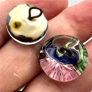 Two glass and paperweight studio buttons.