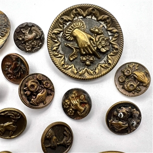 Twenty one assorted brass buttons of hands holding flowers.