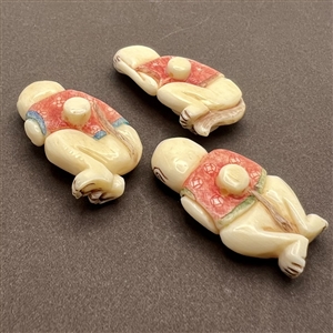 Set of three carved natural material buttons of “see, hear and speak no evil.”