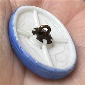 Milk glass rosette shank button with blue of woman’s head.