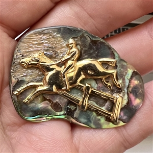 Horse and rider on abalone button.