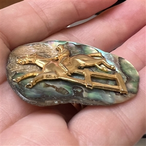 Horse and rider on abalone button.