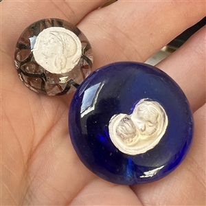 Two paperweight glass buttons with sulfides.