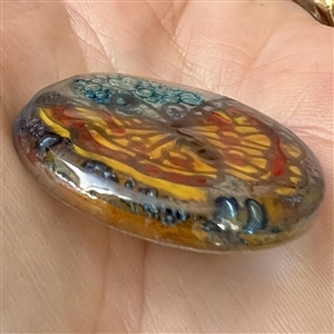 Contemporary fused glass button from an artist in Ecuador of a colorful butterfly.