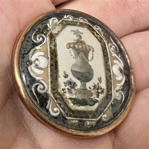 An 18th c. Reverse painted glass of an urn over silvered liner button.