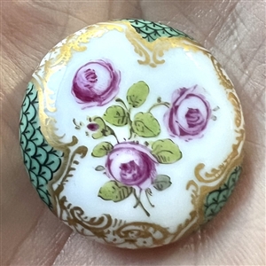 An 18th c. porcelain button of roses and unusual border.
