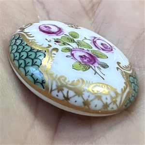 An 18th c. porcelain button of roses and unusual border.