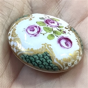An 18th c. porcelain button of roses and unusual border.
