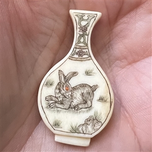 Carved natural material button of a vase.
