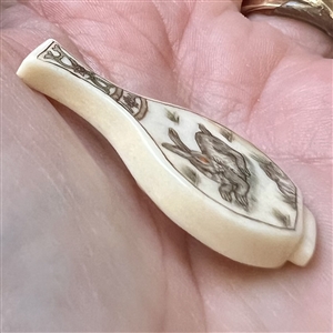 Carved natural material button of a vase.