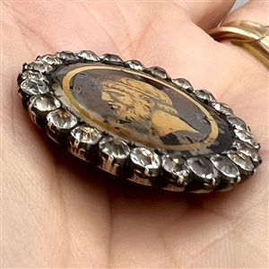 An 18th c. Transitional églomisé of Zeus with paste border in silver button.