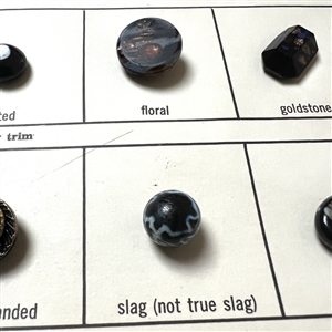 Card of 34 black glass classification buttons.