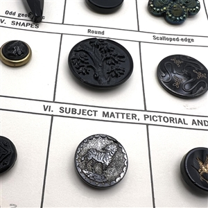 Card of 36 black glass classification buttons.