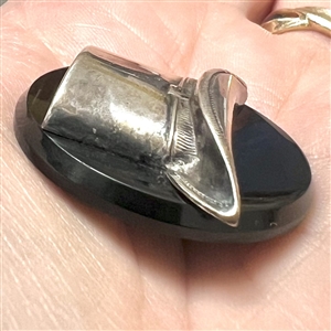 Vintage casein button with silvered metal escutcheon of a top hat.