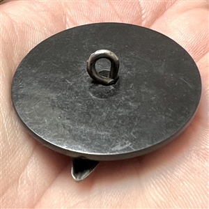 Vintage casein button with silvered metal escutcheon of a top hat.