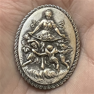 Silvered metal oval button of bountiful goddess with cherubs.
