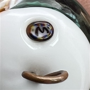 Glass paperweight studio button of fish swimming.